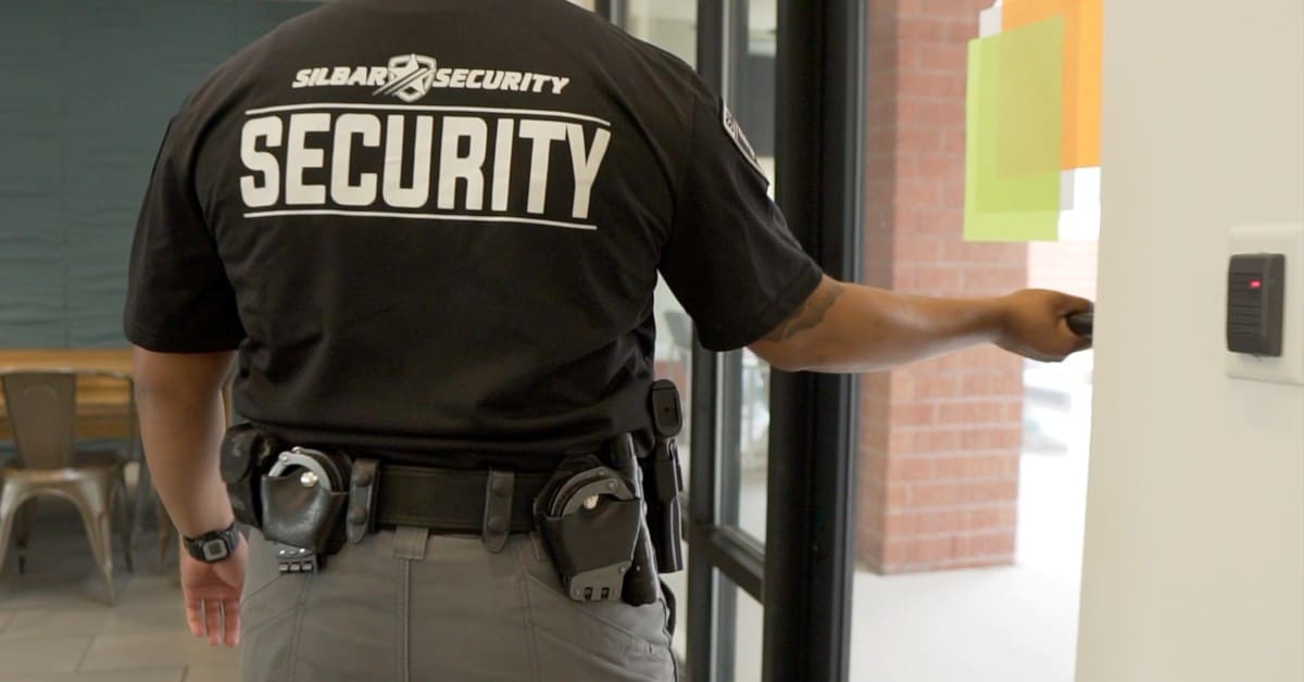 silbar security guard pushing a door open