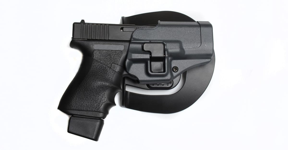 handgun in its holster on a white background