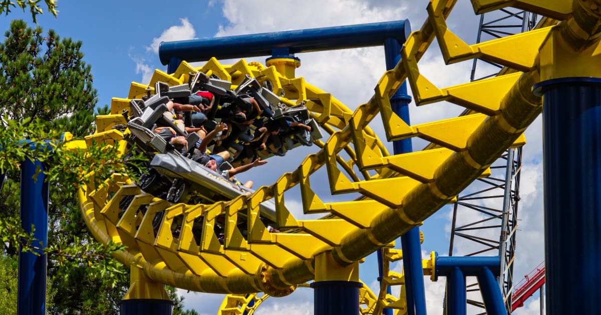 people riding a yellow rollercoaster
