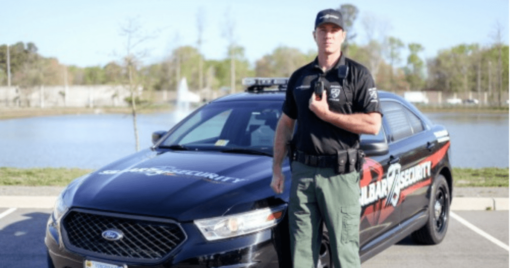 silbar security officer standing in front of a patrol car