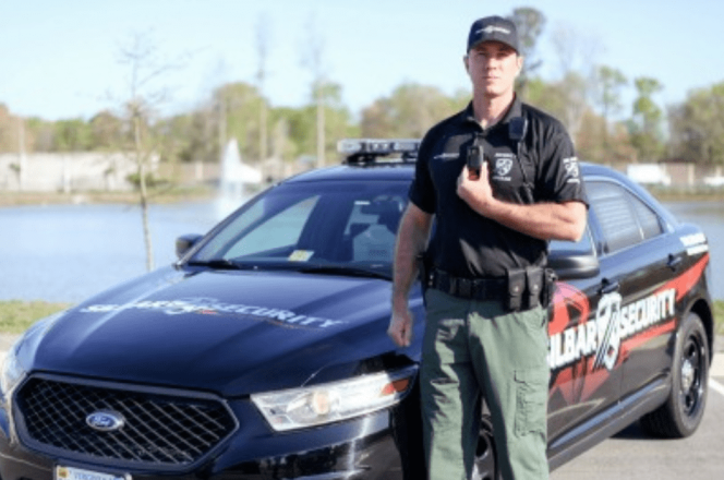silbar security officer standing in front of a patrol car